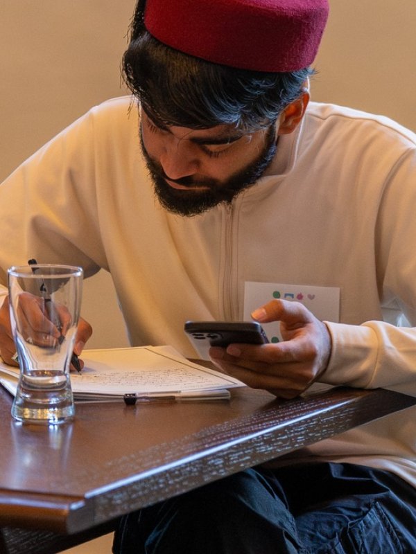 Man sitting at table using phone.
