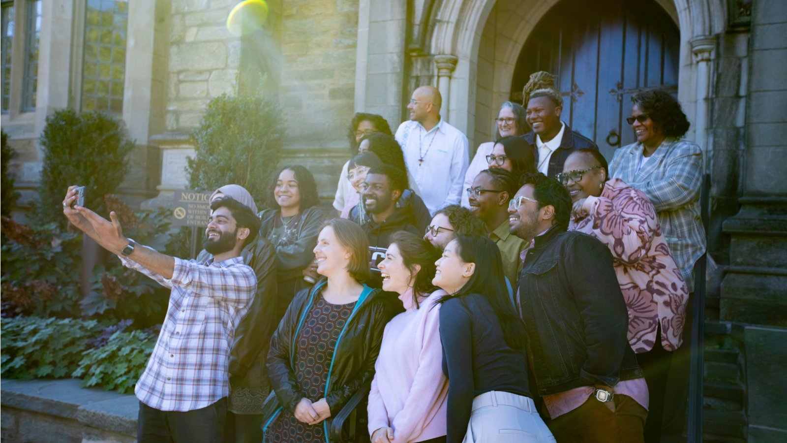 Group taking a selfie on the steps in front of a building